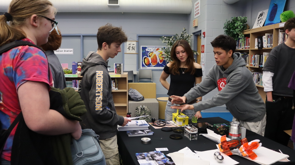 Students standing around a table learning more about New Visions