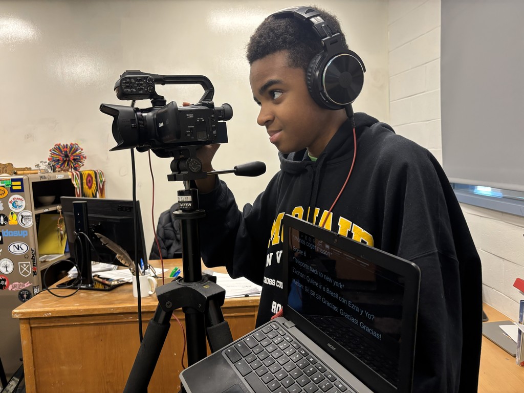 Close up of a student recording video with a teleprompt screen next to them