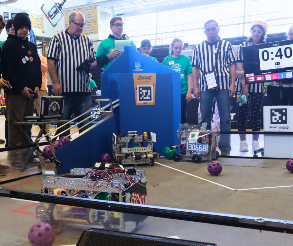The robot in action with refs and students looking on