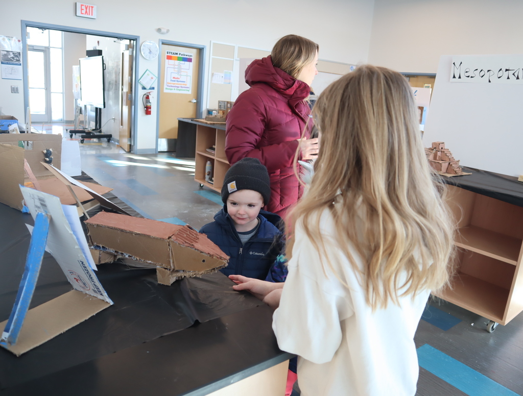 Middle School students looking at student projects for STEAM.