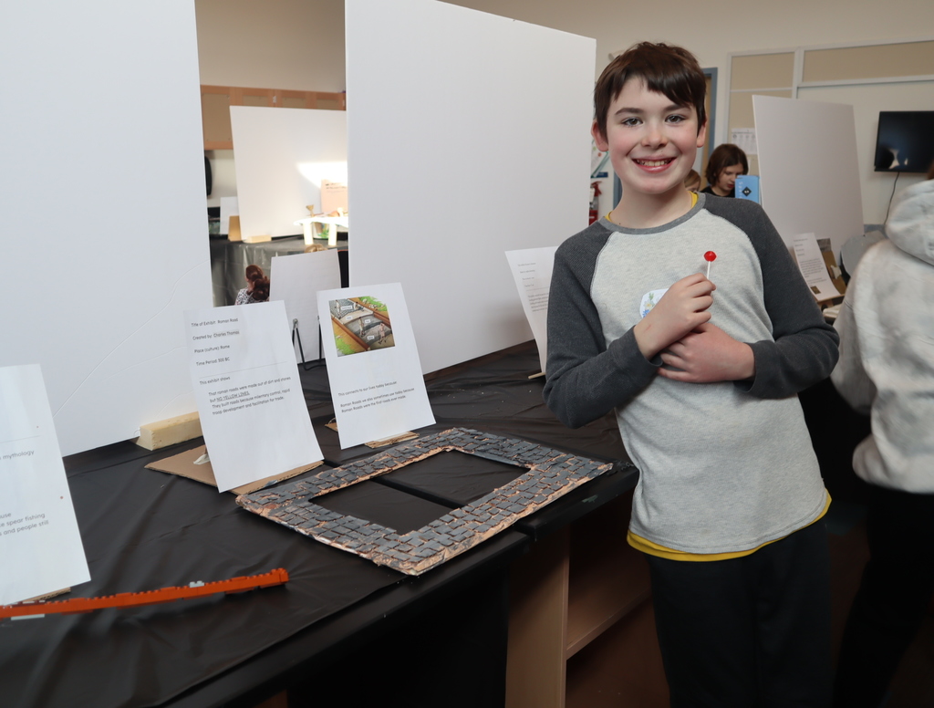 Middle School students looking at student projects for STEAM.