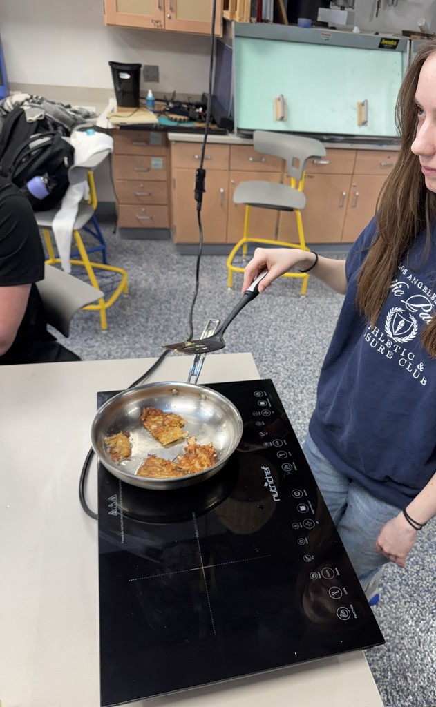 Student frying latkes