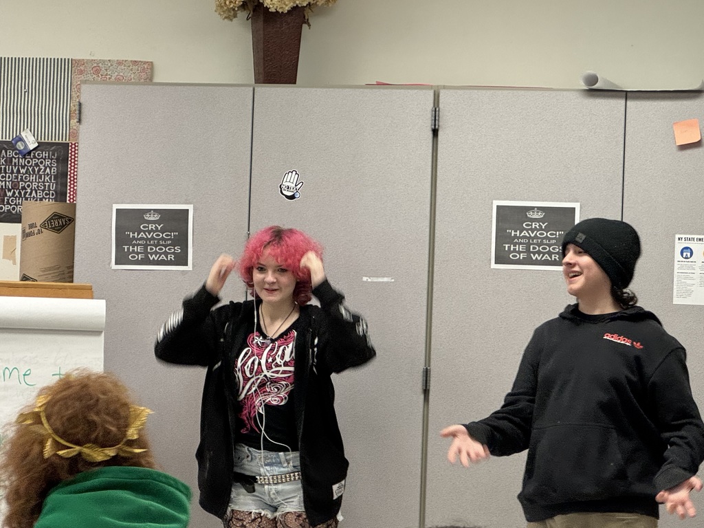 Students smiling and miming putting something on their head