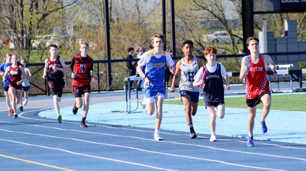 9 students run along a blue track