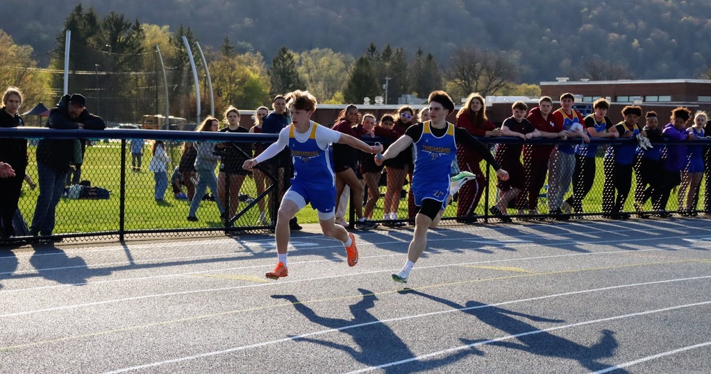 Two students passing a relay baton