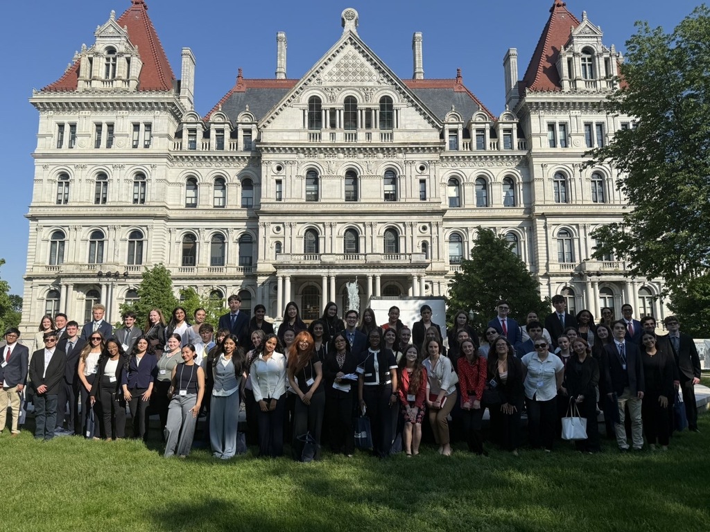 A large group of people standing posed outside of a government building