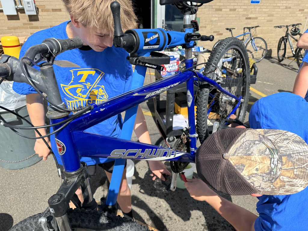 To students use a steel brush and lubrication to fix a bike chain.