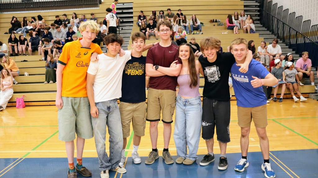 Students smile and line up as a team in the gym