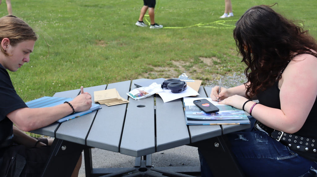 Students signing yearbooks at a table