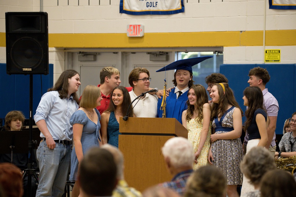 Students singing around a podium