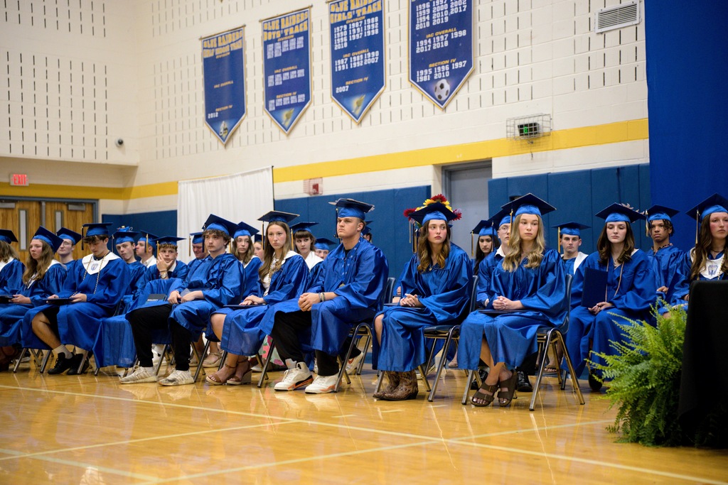 Graduates in caps and gowns sitting in rows