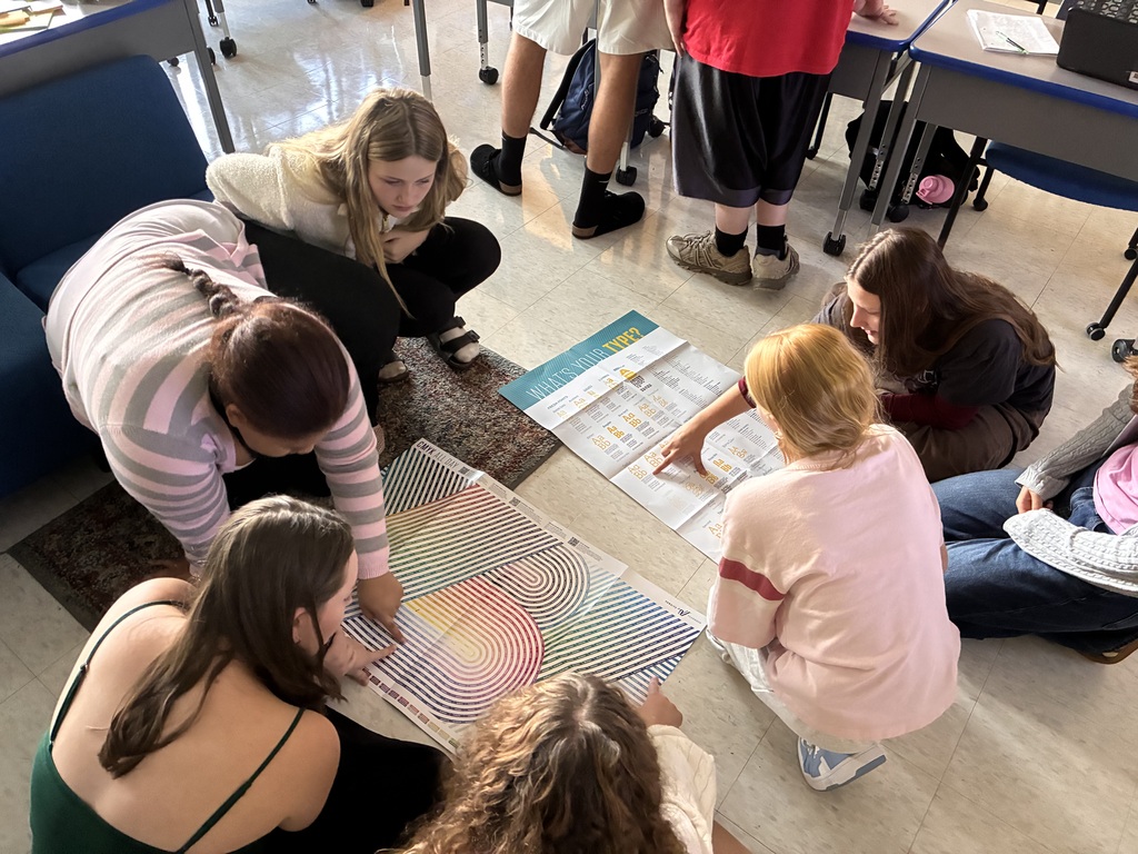 students leaning over color palette poster