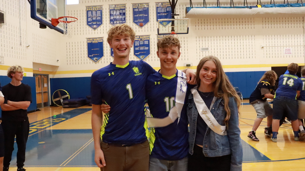 Three students smiling with sashes