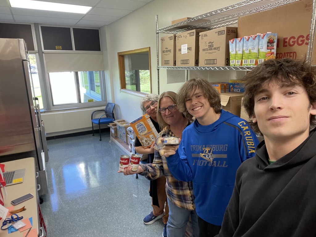 Smiling faces holding food containers in front of shelves