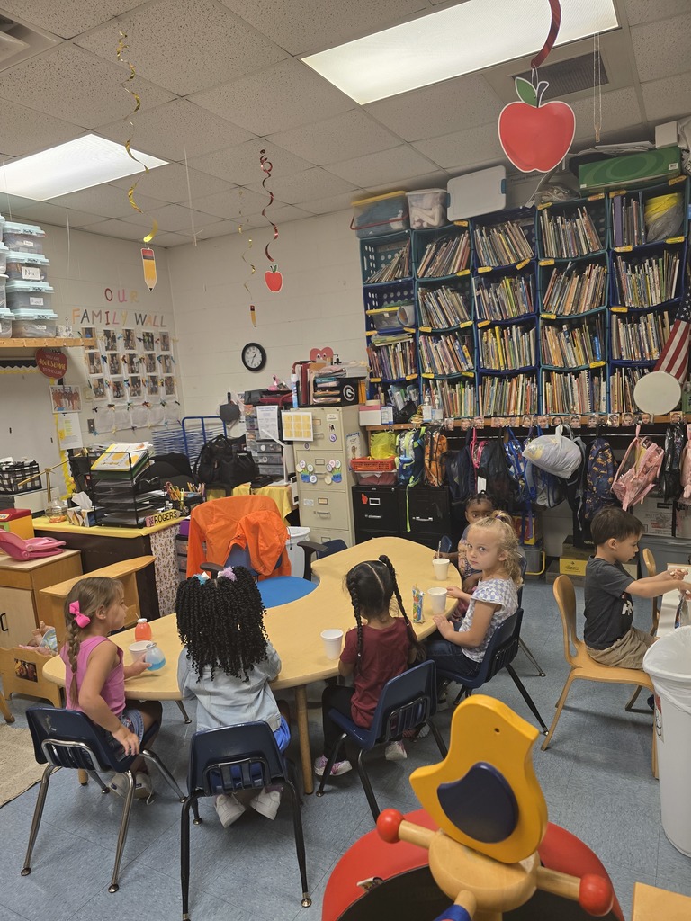 classroom, desks, students, apples hanging from ceiling