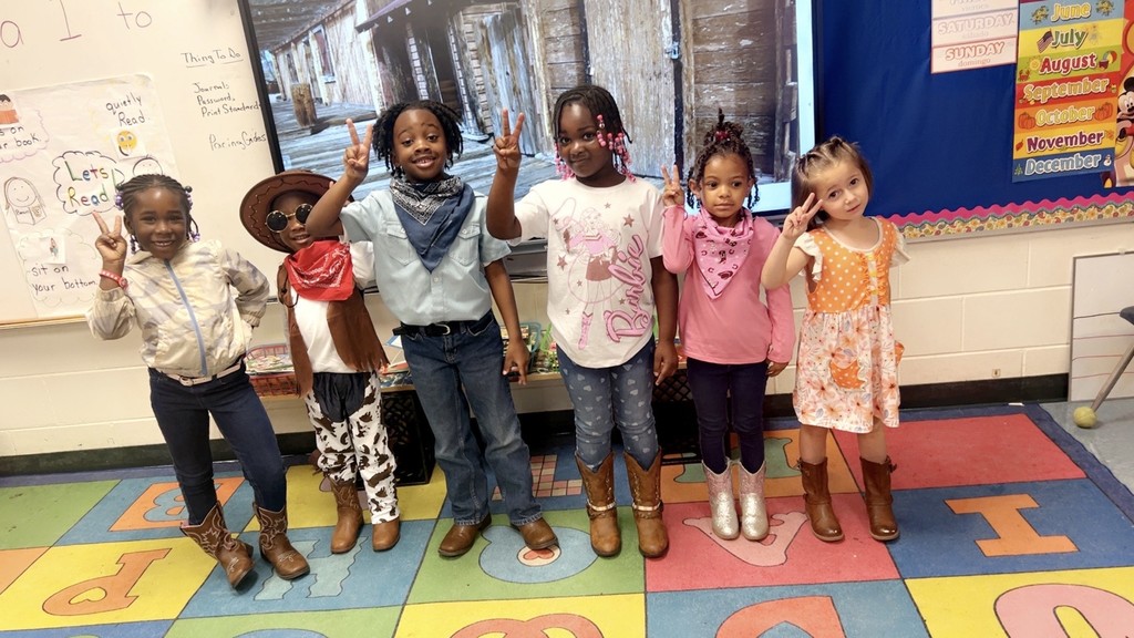 rug with colored squared, students holding peace sign, window, board