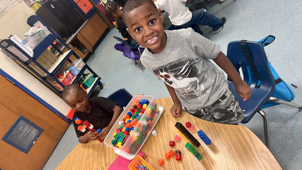 variety of colors and shape of bears, squares, and different objects used for counting, students, desk, classroom