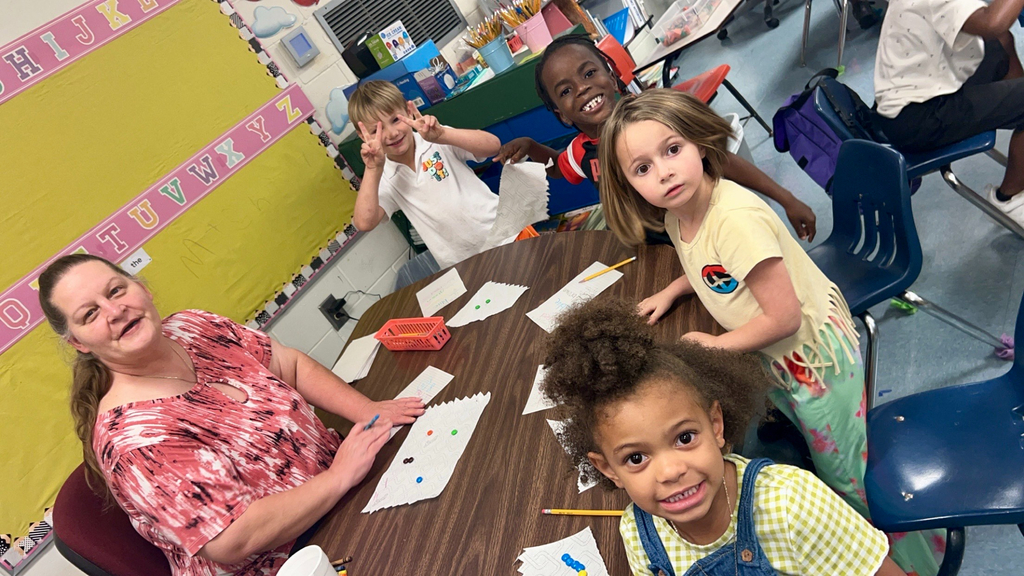 variety of colors and shape of bears, squares, and different objects used for counting, students, desk, classroom, adult