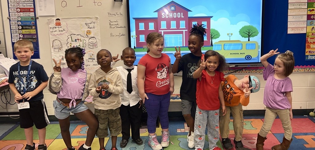board with schoolhouse and bus on display, students, colored ABC square rug
