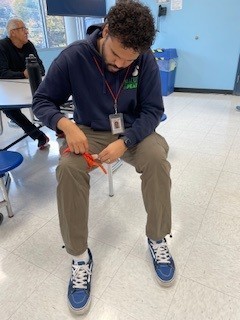 Teacher practices applying tourniquet to himself.