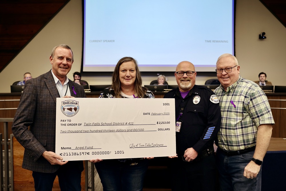 Shawn Barigar, city planner, Jenny Herzog, TFSD Homeless coordinator, Craig Kingsberry, TFPD Cheif of Police, and Craig Hawkins, City Counsel, pose for a picture with a big check