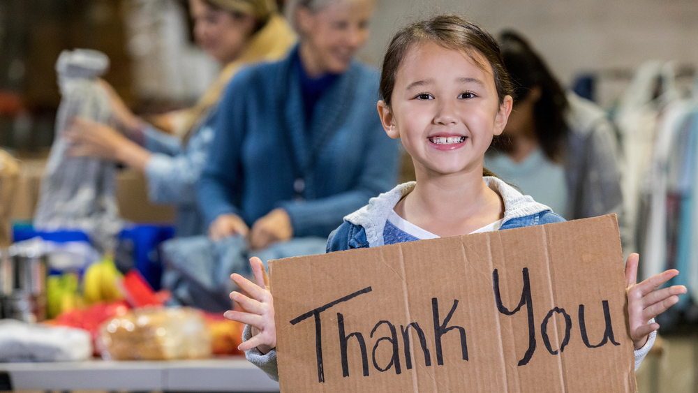 Child holding a sign that says Thank You