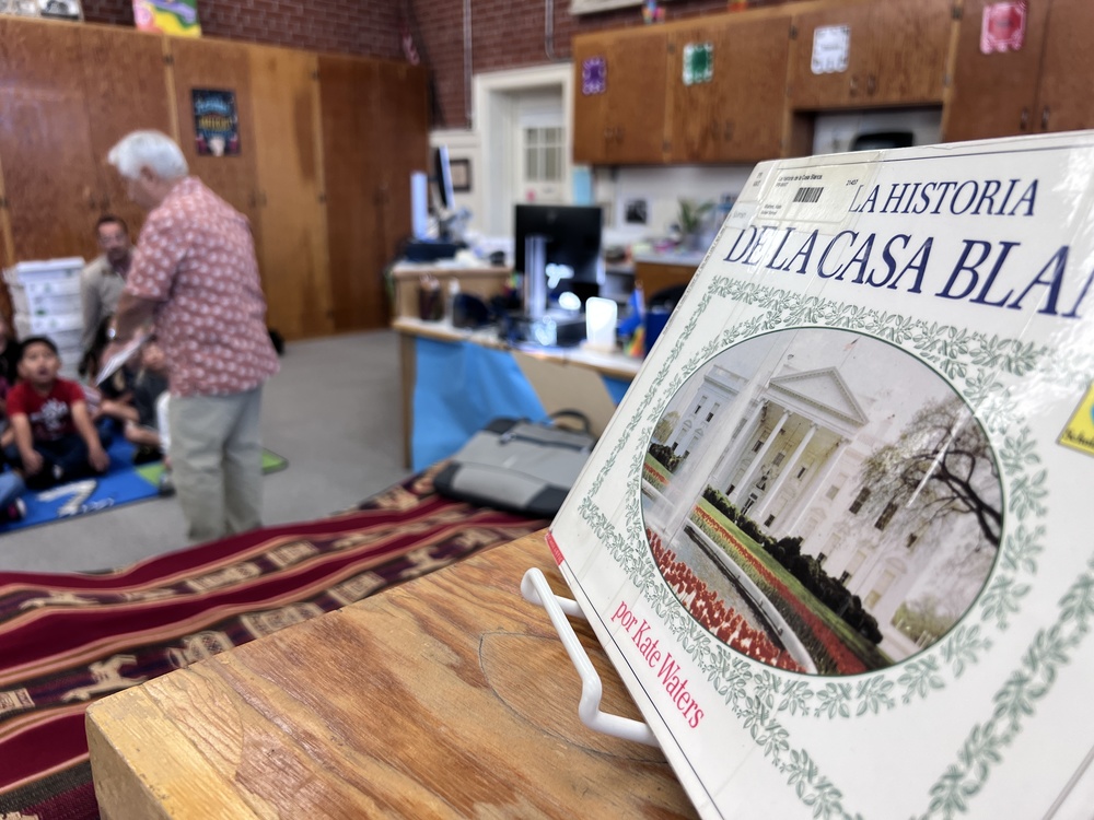 a book in spanish with an author in the background.
