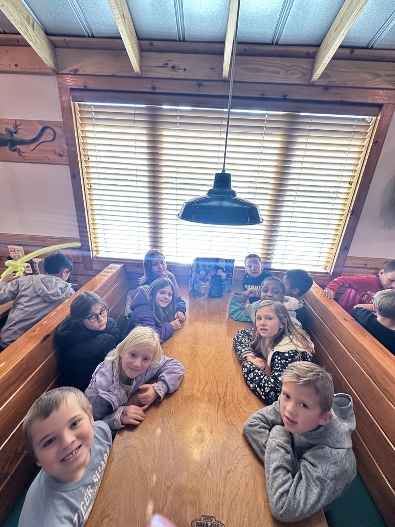 Students smiling in booth at Texas Road House
