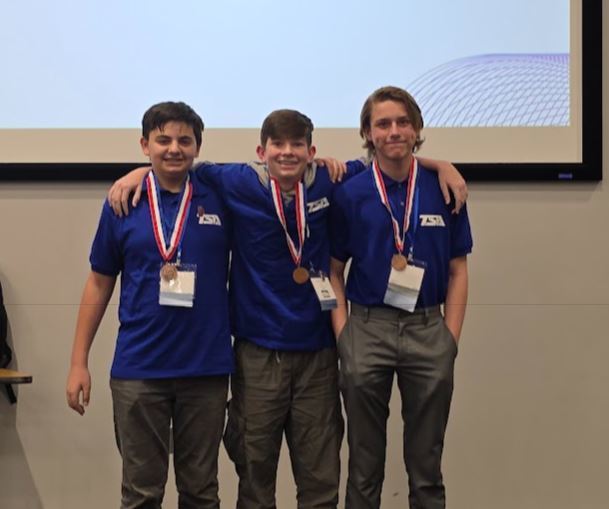 Group of three boys with bronze medals around their necks