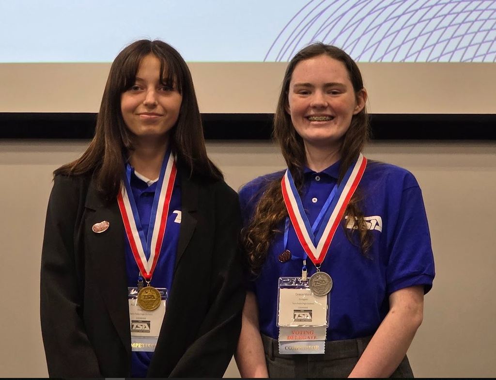 Girl with a gold medal and girl with a silver medal around their necks