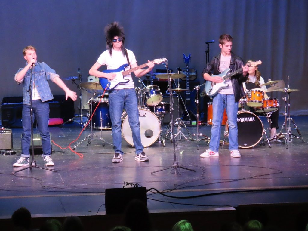 TFHS students playin on stage in rock gear for battle of the bands at TFHS.