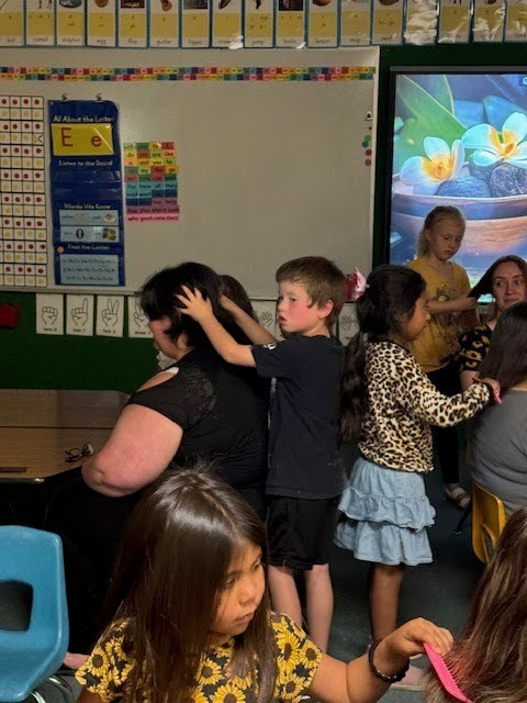 A classroom doing their moms hair.