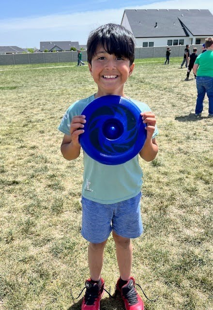 A student holding a frisbee at rock creek elementary school feild day.