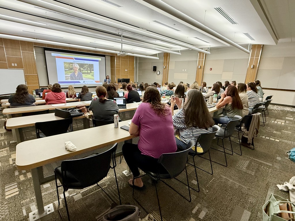 A room full of teachers listening to an instructor.