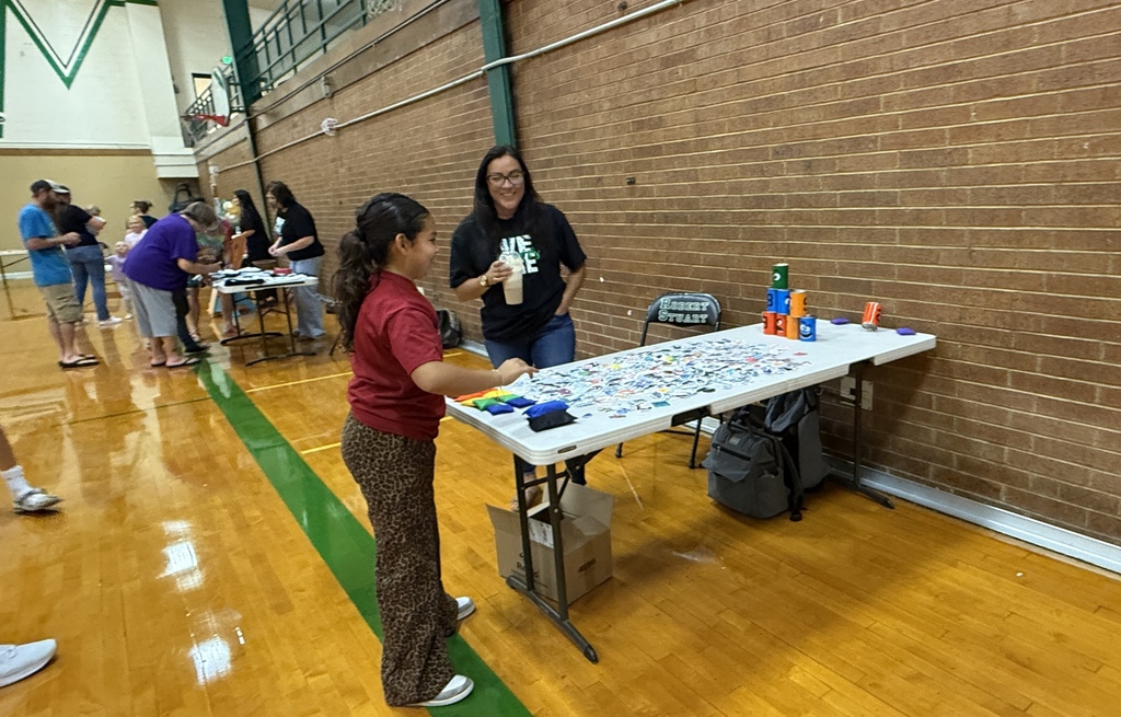 A student in the gym playing a game at a table.