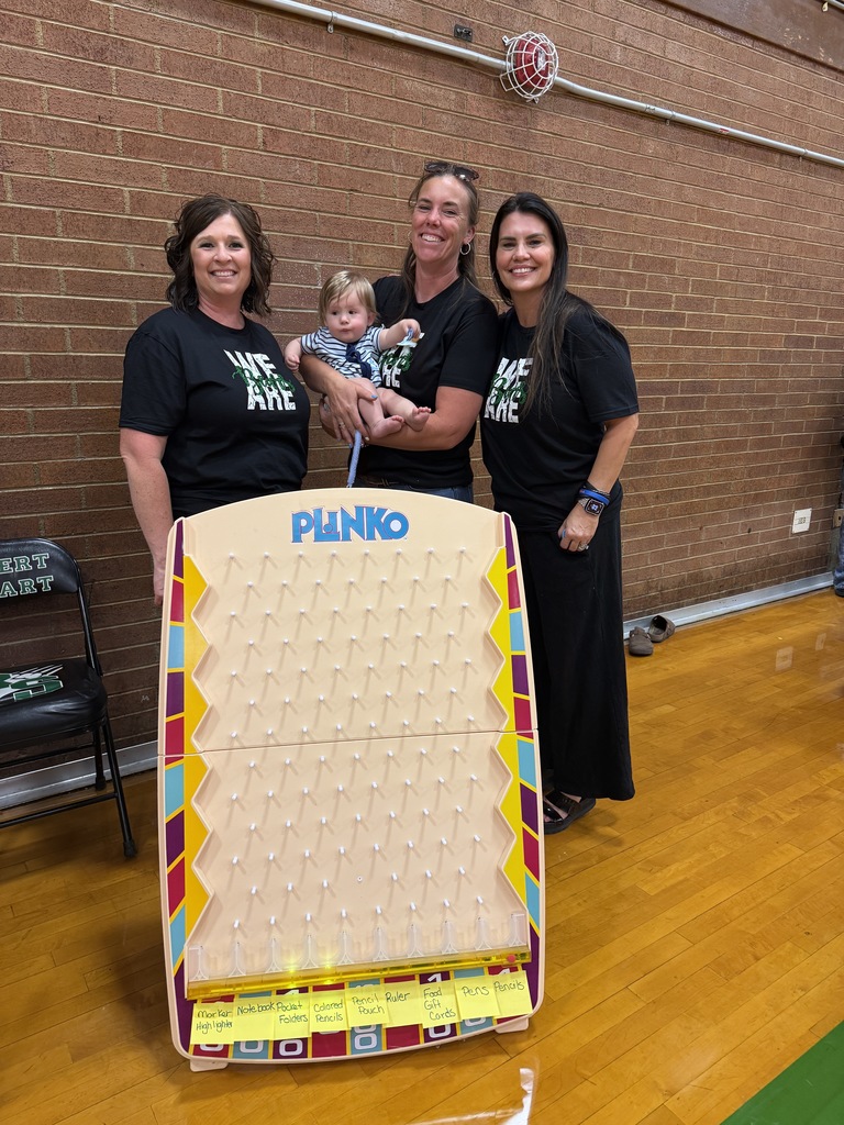Three parents standing in front of a PLINKO board.