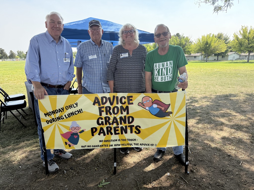 Four grandparents standing in front of a sign that says Advice From GrandParents.