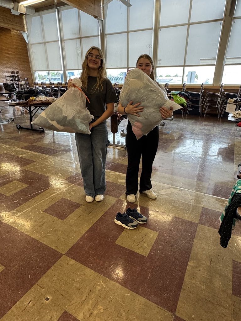 Two girls each holding a trashbag full of their loot!
