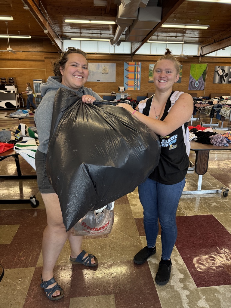 Two women holding a trashbag full of their loot!