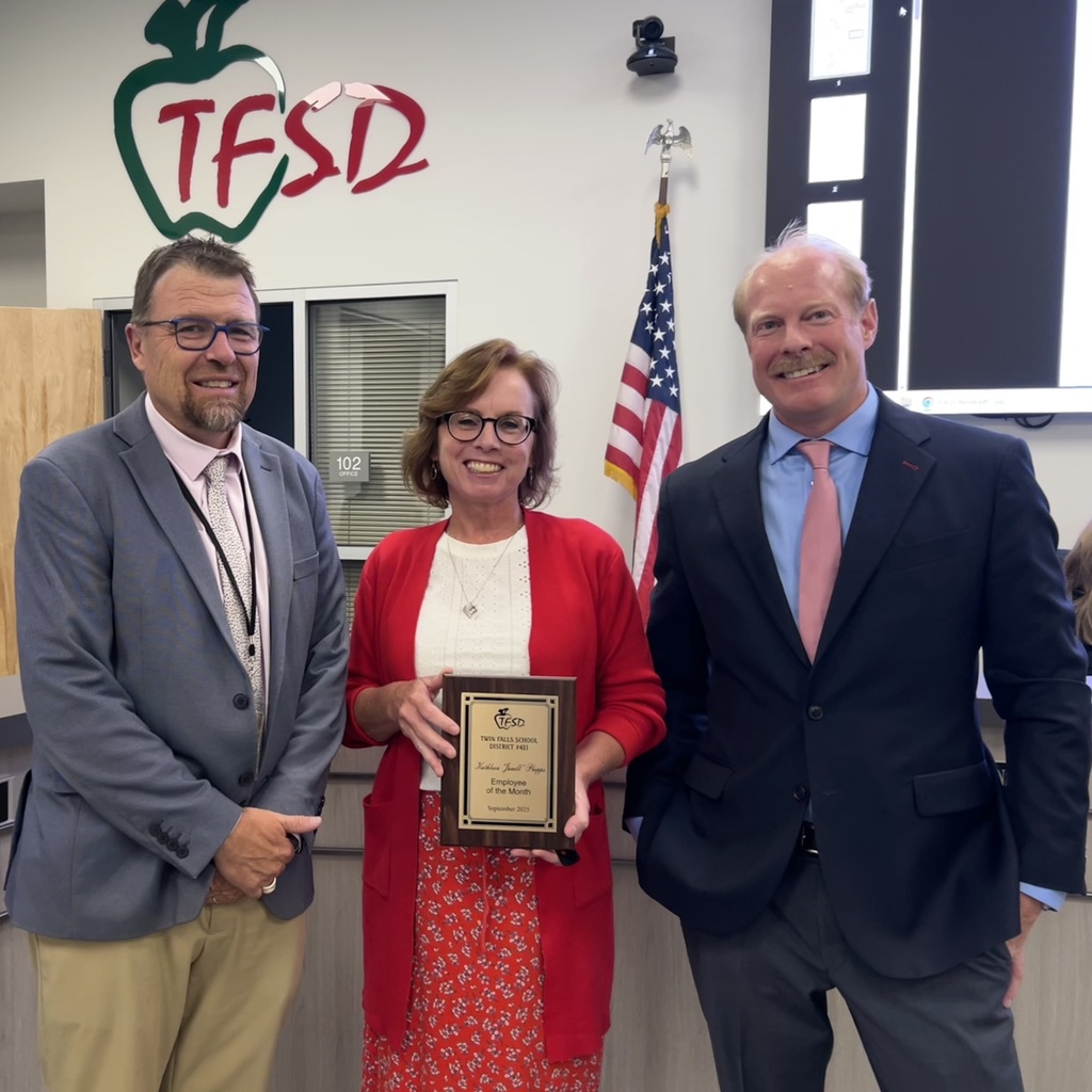 Janell Phipps September employee of the month with her plaque and superintendent Dickenson and Board memeber Eric.