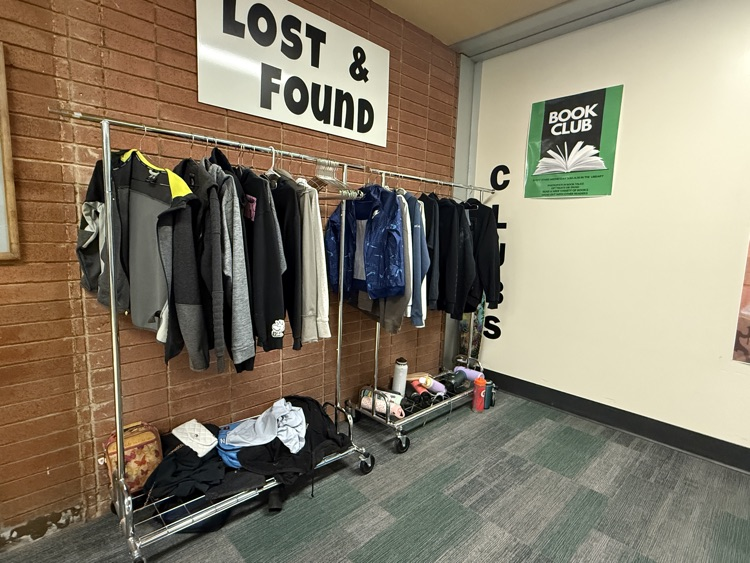 a picture of list and found items on a rack against a brick wall 