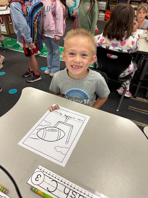 student coloring a football picture