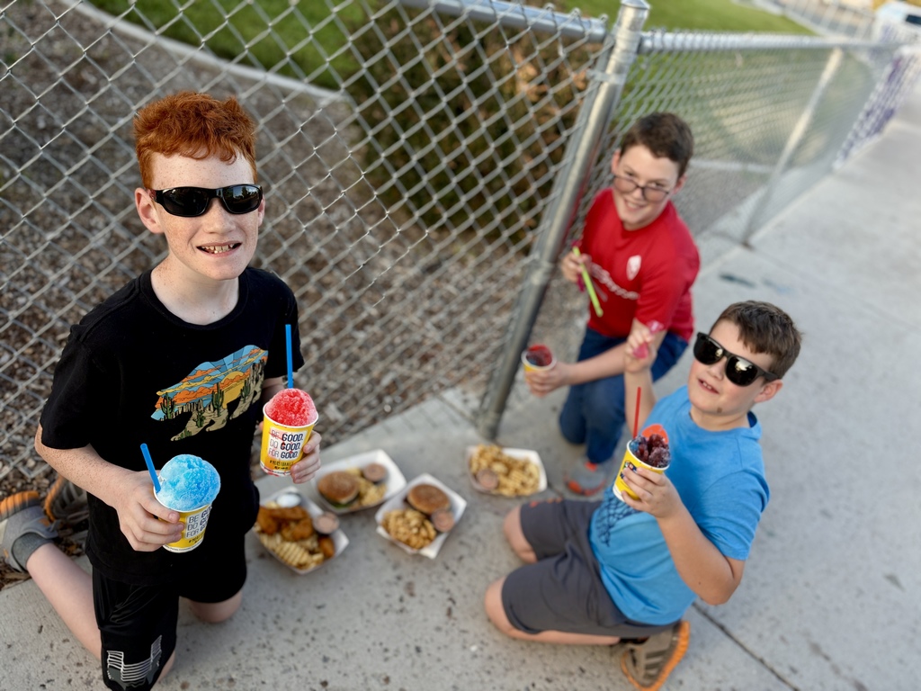 boys with food and slushies by a fence