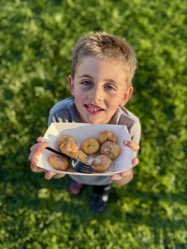 boy holding bowl of donuts
