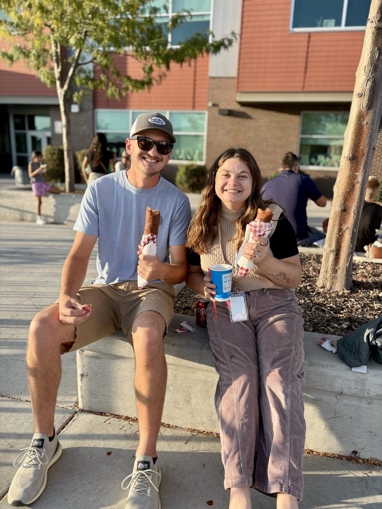 couple eating corn dogs at school