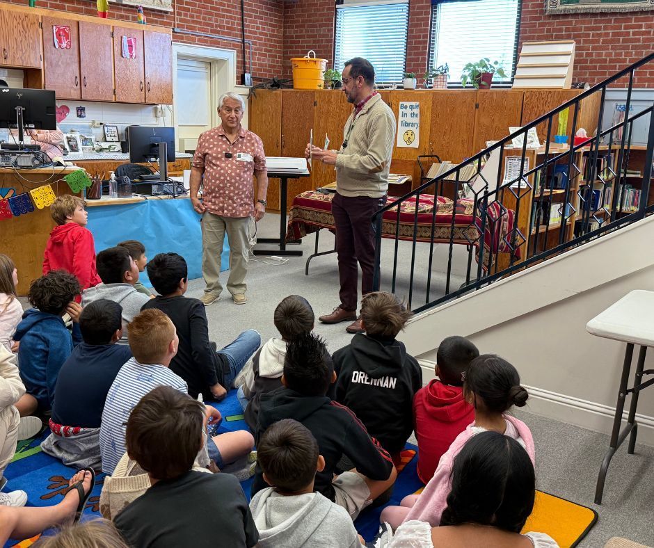 two men telling a group of kids about the books
