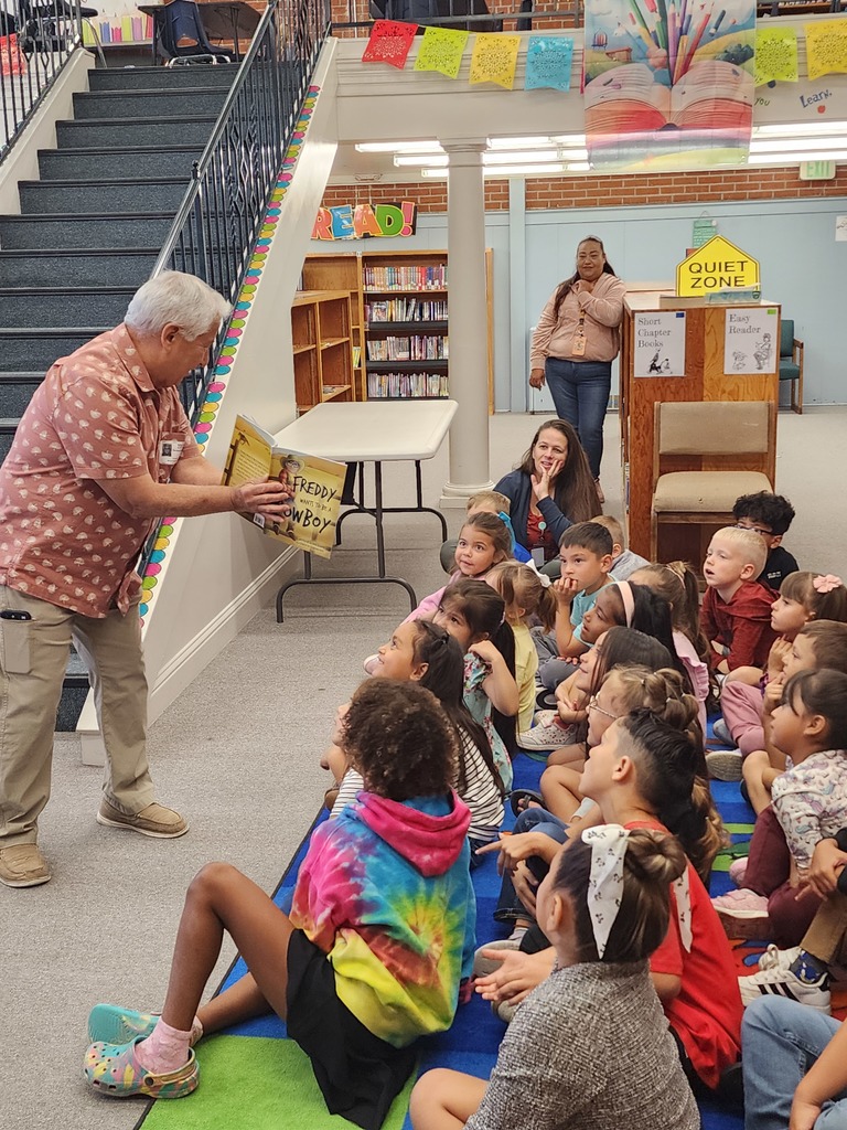 man showing his book to a group of children