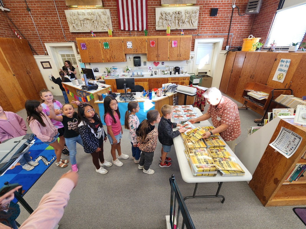Children recieving books from the author