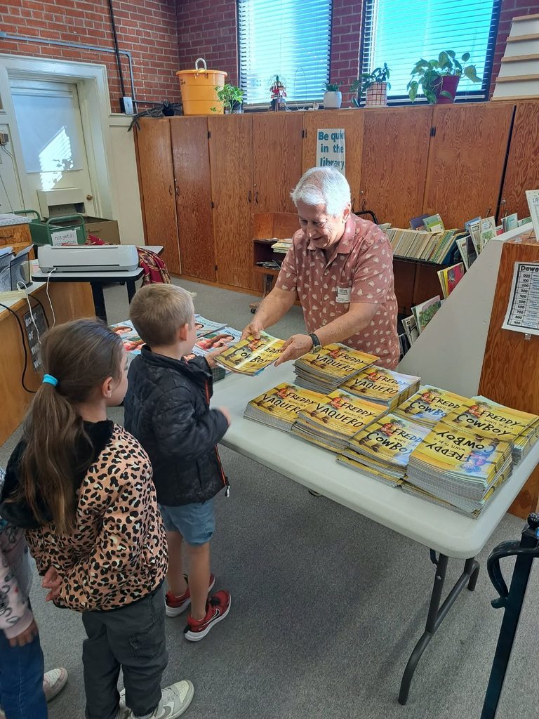 Children's Author Richard Aldama giving out free books to Bickel students in english ands spanish.