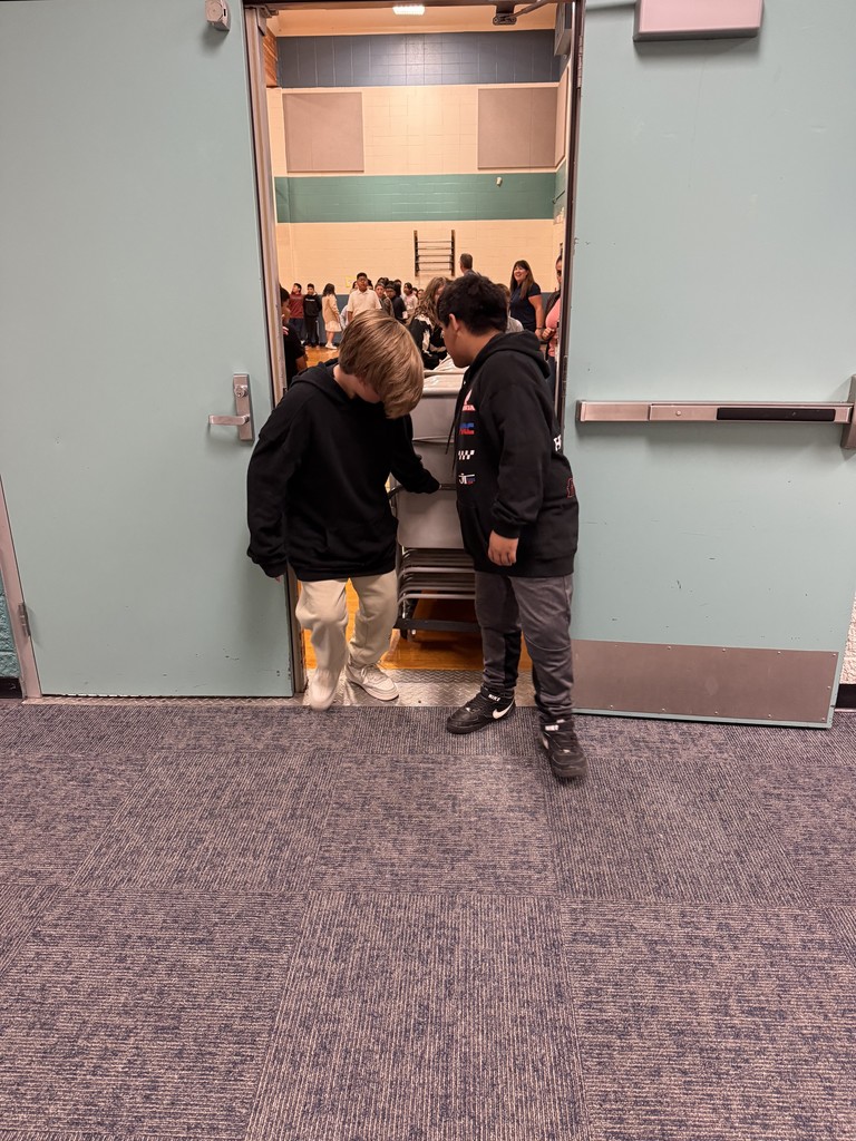 Students helping clean up from assembly